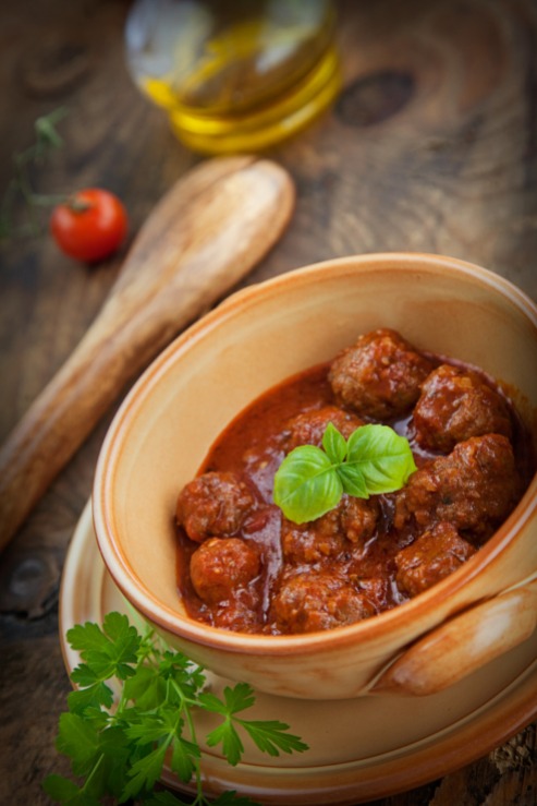 Italian cooking - meat balls with basil, tomatoes, olive oil and garlic